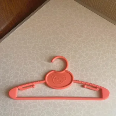 Cintre pour enfant en plastique souple de couleur rose, avec adorable motif ourson.